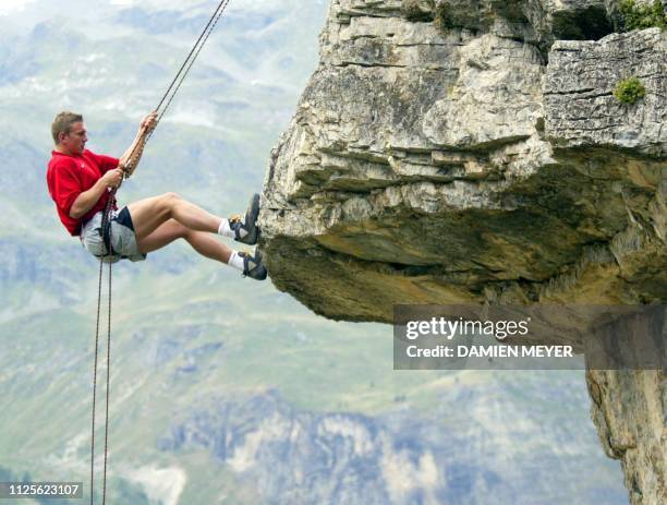 Le joueur du XV de France Imanol Harinordoquy descend en rappel une paroi le 04 août 2003 pendant une initiation à l'escalade près de Val d'Isère...