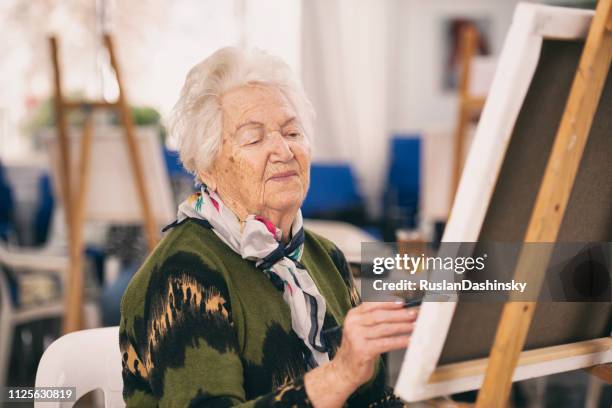 old woman taking an art class. - art class stock pictures, royalty-free photos & images