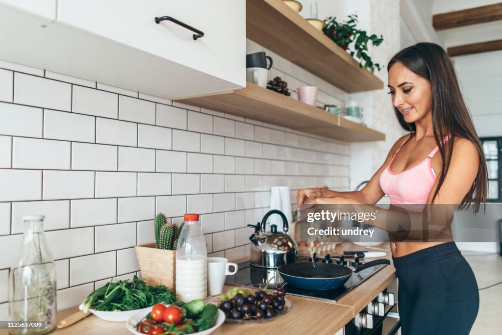 Monter la femme fissuration des oeufs dans la poêle à frire