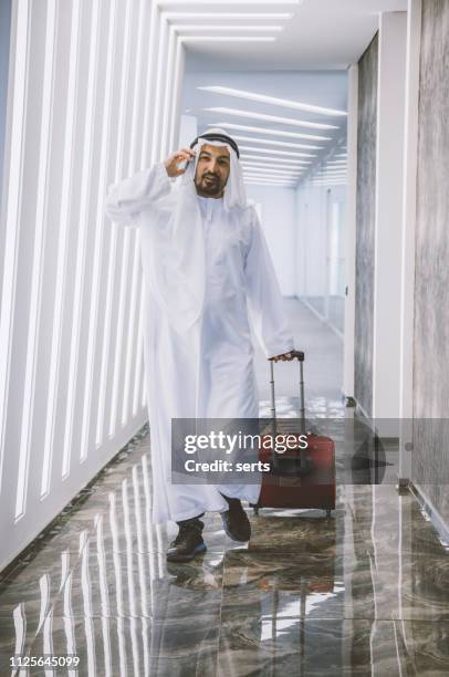 traveler middle eastern businesman mit gepäck zu fuß zum flugzeug auf dem flughafen - saudi arabia business stock-fotos und bilder