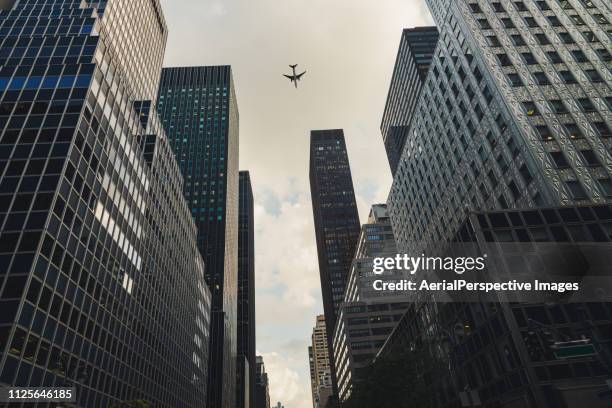 airplane flying in manhattan - low angle view of airplane stock pictures, royalty-free photos & images