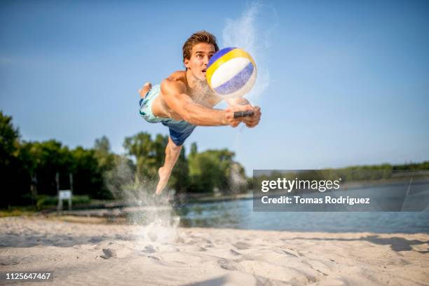 beach volleyball player digging the ball - sprung ins wasser stock-fotos und bilder