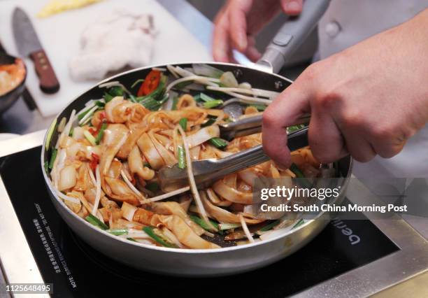 Jesse Teh, head chef of Secret Ingredients, demonstrates how to make prawn char kway teow. 19NOV13