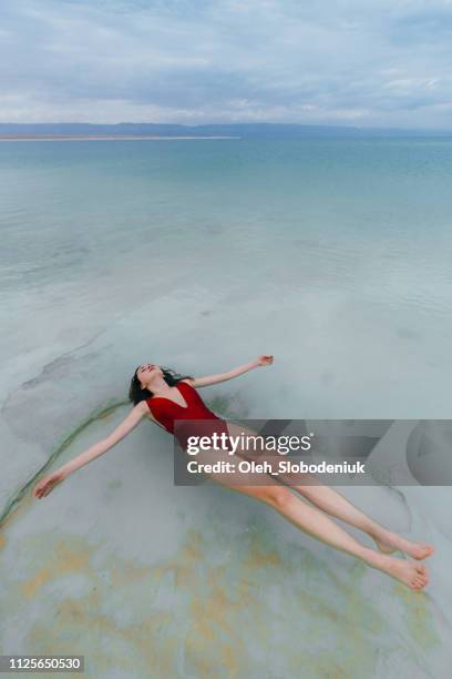 woman floating on water  in dead sea - dead sea float stock pictures, royalty-free photos & images