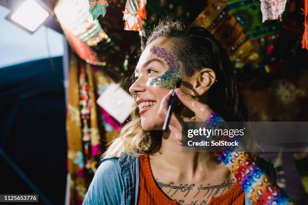 glittery krijgen voor het festival - geschminkt gezicht stockfoto's en -beelden