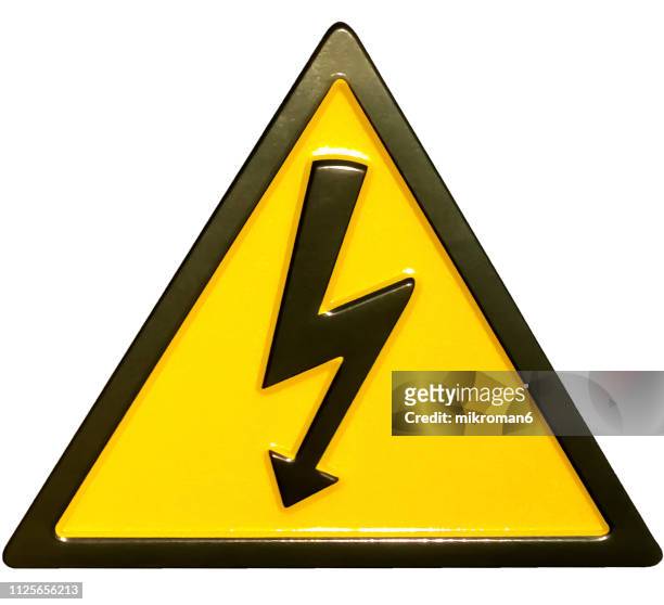close-up of yellow high voltage sign - alto voltaje fotografías e imágenes de stock