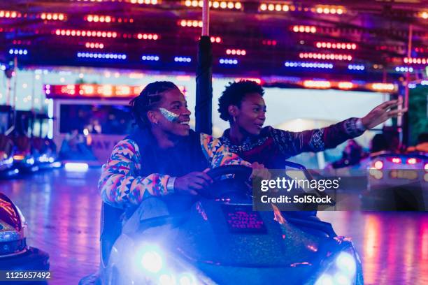 young couple on the dodgems - driving romance stock pictures, royalty-free photos & images