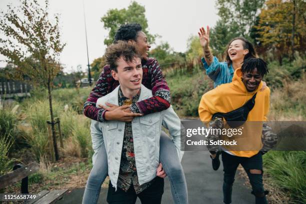 couples piggybacking in the park - double date stock pictures, royalty-free photos & images