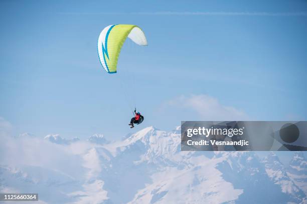paraglider over mountains - man snow wind stock pictures, royalty-free photos & images