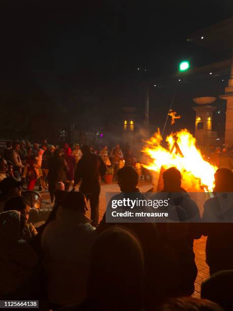 image of punjab lohri festival holiday crowds in new delhi, india, with indians dancing around bonfire flames - lohri festival imagens e fotografias de stock