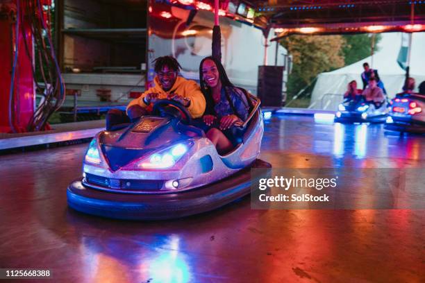 young couple on bumper cars - arcade game stock pictures, royalty-free photos & images