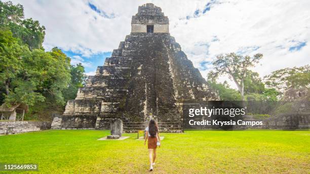 girl walking to base of mayan pyramid in guatemala - tikal stock pictures, royalty-free photos & images