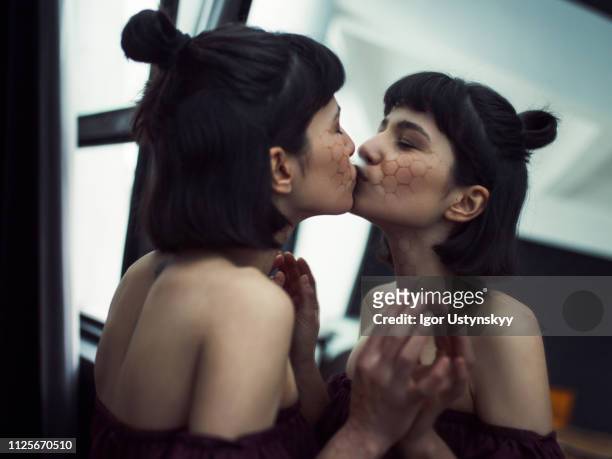 young woman kissing her reflection - vanity stock pictures, royalty-free photos & images