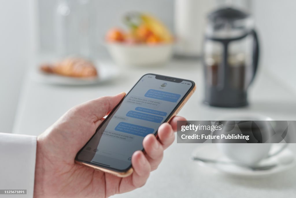 Man Using Smartphone In Kitchen