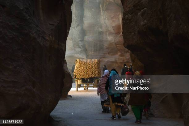 Tourists seen inside the Siq, the main entrance to the ancient Nabatean city of Petra, that starts from the Dam and ends at Petra's most elaborate...