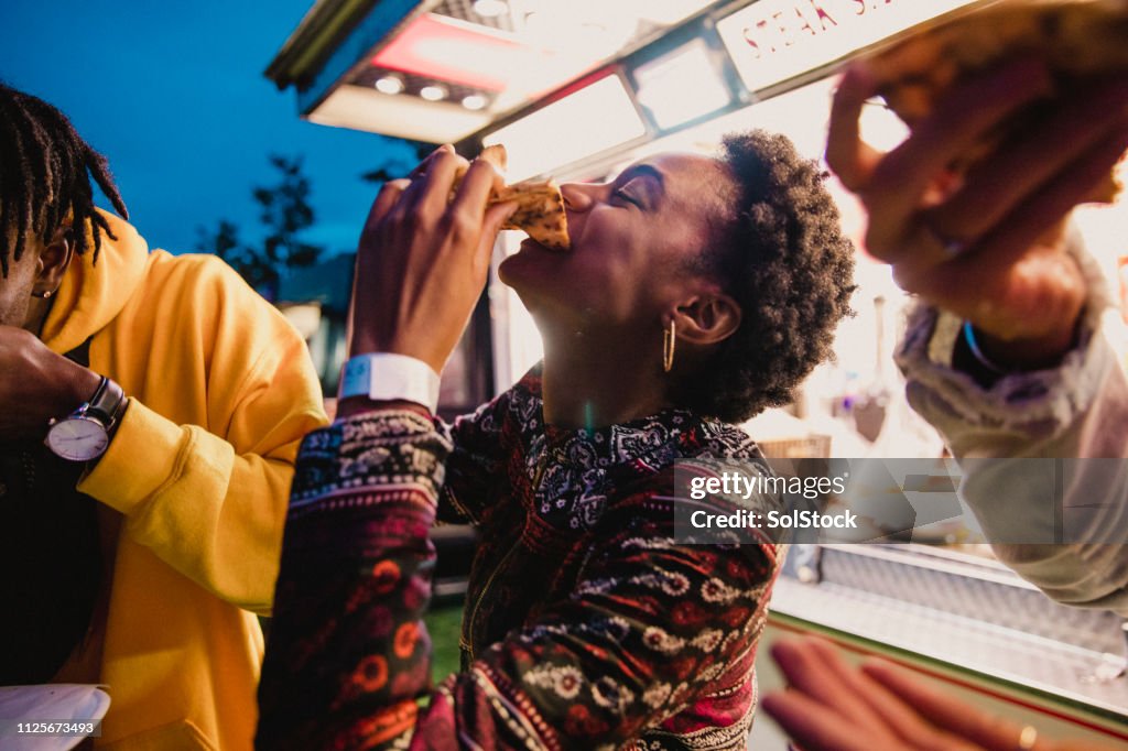Giovane donna che mangia pizza al Festival