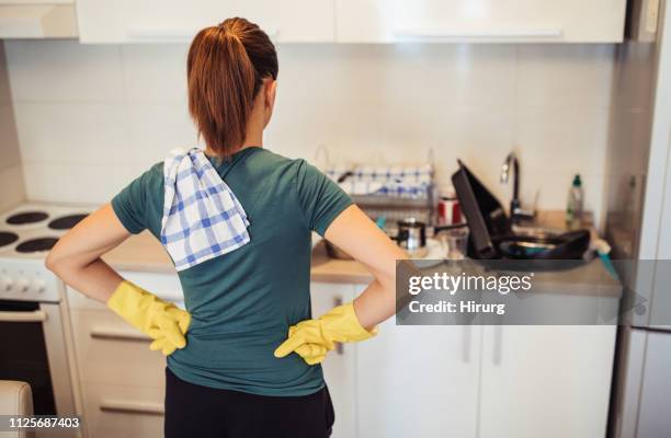 hausfrau und schmutziges geschirr in der spüle - stereotypical housewife stock-fotos und bilder