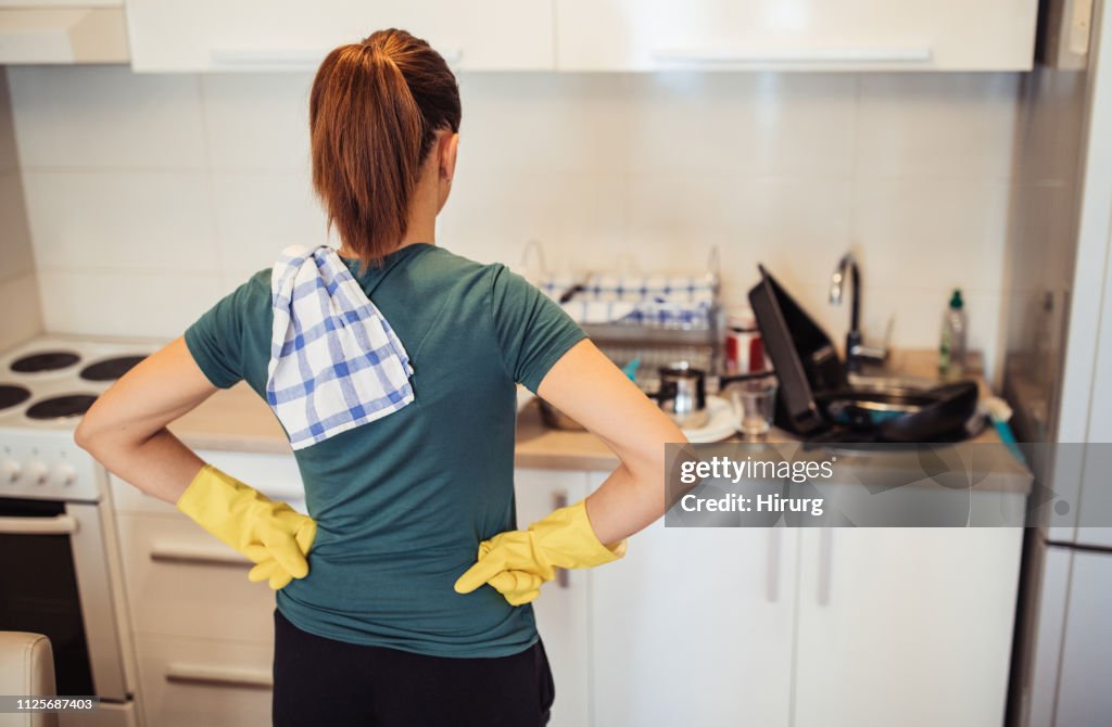 Housewife and dirty dishes in the sink
