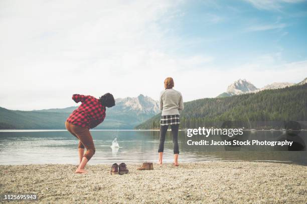 two people by a lakefront - skimming stones stock pictures, royalty-free photos & images