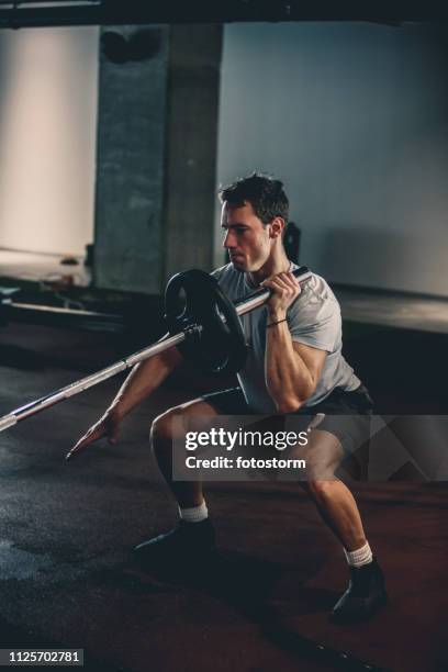 man doing single-arm landmine squat-to-press exercise - weightlifting stock pictures, royalty-free photos & images