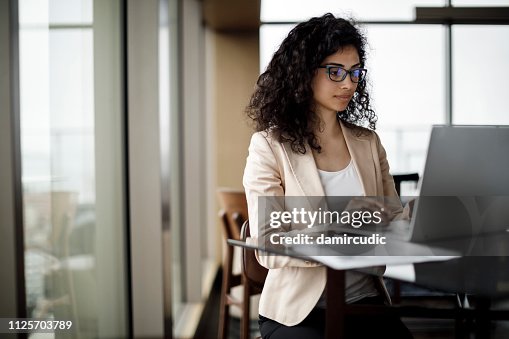 Businesswoman working on laptop in a coffee shop Businesswoman working on laptop in a coffee shop