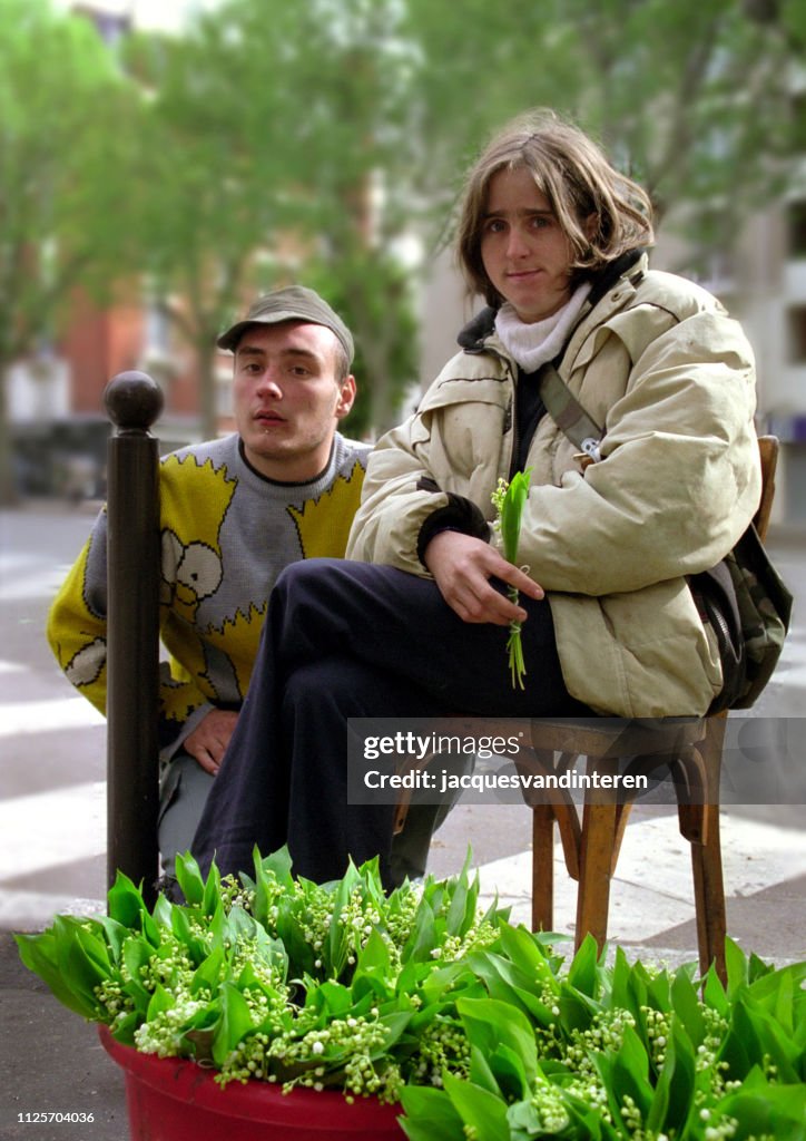 Dos jóvenes vendiendo un lirio de los valles en París el primero de mayo