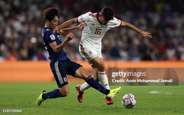 Mehdi Torabi of Irana and Haraguchi Genki of Japan in action during the AFC Asian Cup semi final match between Iran and Japan at Hazza Bin Zayed...