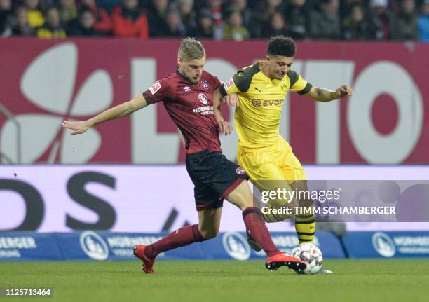 Nuernberg's German midfielder Hanno Behrens and Dortmund's English midfielder Jadon Sancho vie for the ball during the German first division...