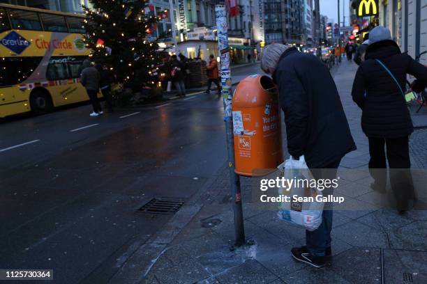 Man looks into a garbage bin looking for bottles in order to redeem their deposit on January 9, 2019 in Berlin, Germany. Germany has among the...