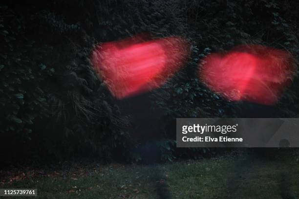 blurred motion of person holding a red heart and moving towards a second person with a red heart, running away from the first - gap closers stock pictures, royalty-free photos & images