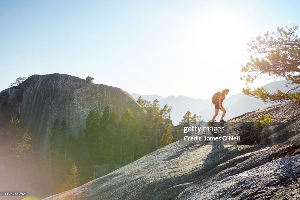 Female hiker going uphill with distant peaks