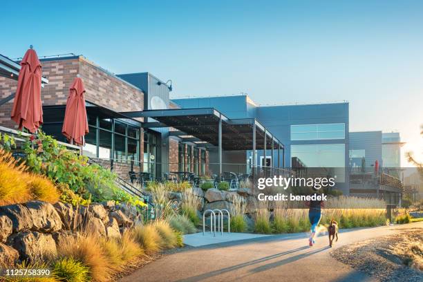 vrouw jogs aan spokane river boulevard in het centrum van spokane washington - spokane stockfoto's en -beelden