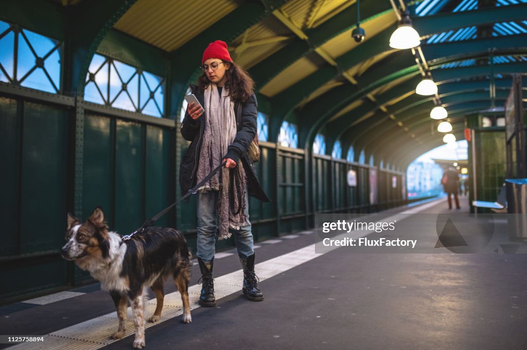 Retro girl and her dog on a railroad station