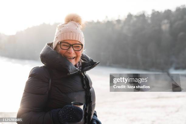active seniors exploring the swedish winter landscapes - senior woman walking stock pictures, royalty-free photos & images