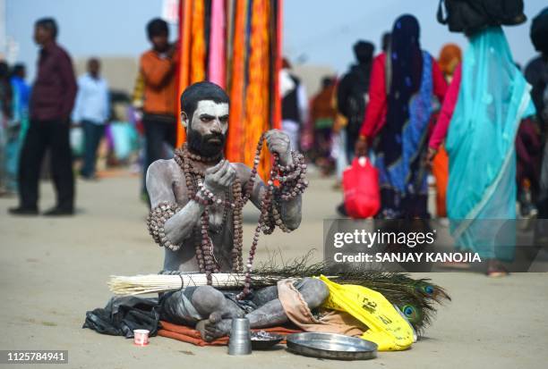 An Indian sadhu sits on the banks of Sangam -- the confluence of the Ganges, Yamuna and mythical Saraswati rivers -- on the auspicious bathing day of...