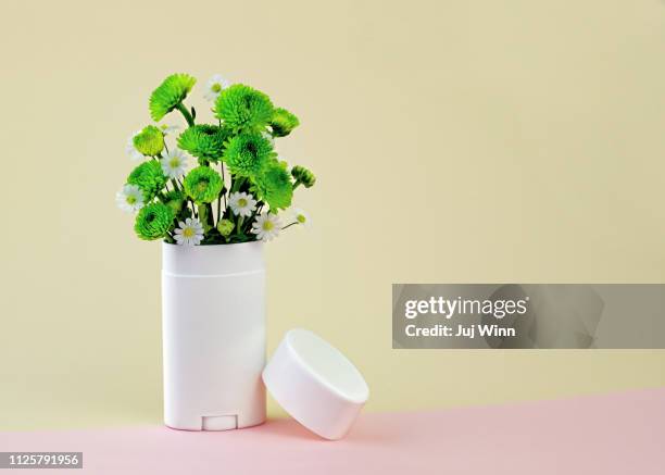 white and green flowers in a deodorant container - deodorant stock-fotos und bilder