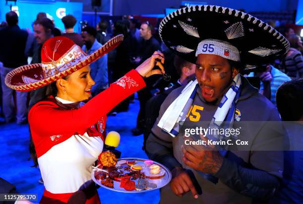 Ethan Westbrooks of the Los Angeles Rams reacts as he is offered a scorpion from a reporter from Televisa during Super Bowl LIII Opening Night at...