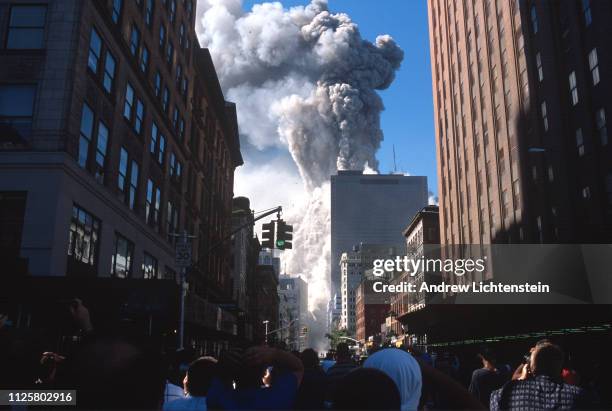 Crowd of onlookers watches from West Broadway as the second World Trade Center crumbles in an explosion of smoke and ash, September 11, 2001 in New...
