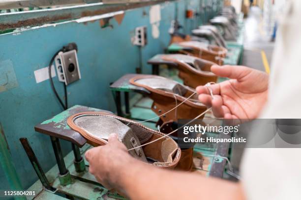 extreme nahaufnahme von unkenntlich mann am fließband nähen stiefel - shoe factory stock-fotos und bilder