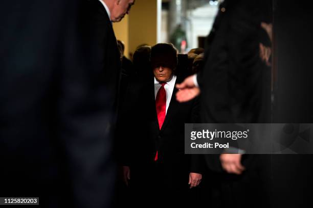 President Donald Trump walks through the doors to the House Chamber to deliver the State of the Union address in the chamber of the U.S. House of...