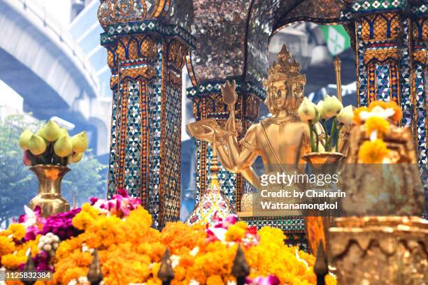 erawan shrine with sky train rail in background at ratchaprasong intersection, bangkok. - brama stock pictures, royalty-free photos & images