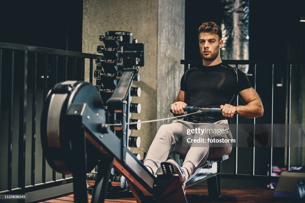 Dedicated athlete exercising on rowing machine