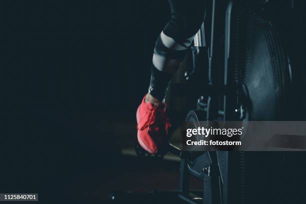 woman pedaling on fan bike - stationary cycling class stock pictures, royalty-free photos & images