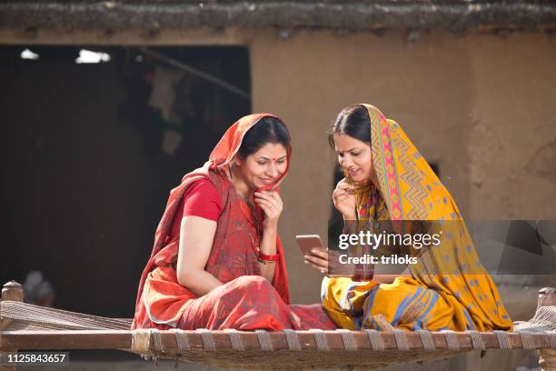 rural women using mobile phone at village - indian village people stock pictures, royalty-free photos & images