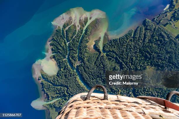 aerial view on a lake shore, a river and a nature reserve seen from a hot air balloon. - hot air balloon ride stock-fotos und bilder
