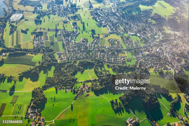 germany, bavaria, rural landscape and the town of prien am chiemsee. aerial view - field no people stock-fotos und bilder