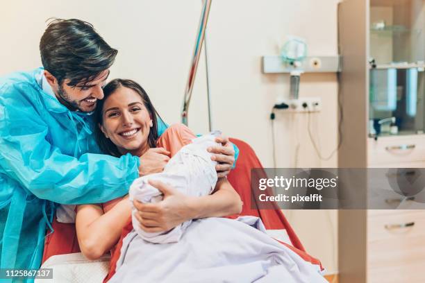 happy couple after the delivery of their baby - family photo in the delivery room stock pictures, royalty-free photos & images