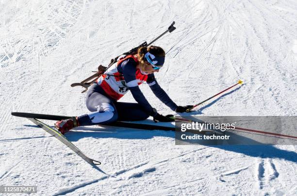 front view of female biathlon competitor resting after the tiring race - biathlon ski stock pictures, royalty-free photos & images