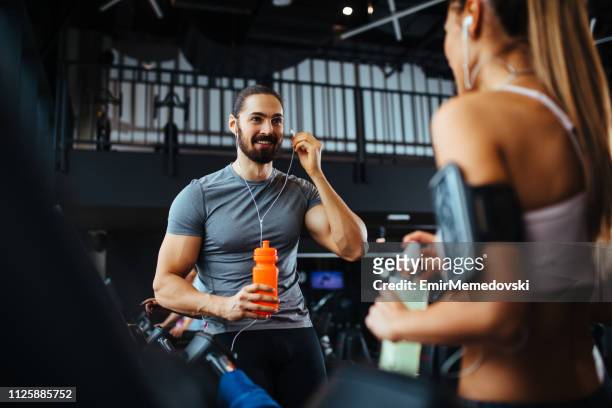 young people talking while exercising in a health club - flirt stock pictures, royalty-free photos & images