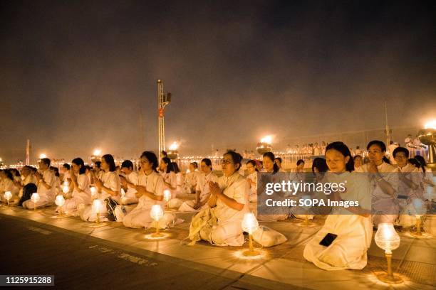 Devotees seen meditating with their lanterns during the yearly Makha Bucha ceremony. Buddhist devotees celebrate the annual festival of Makha Bucha,...